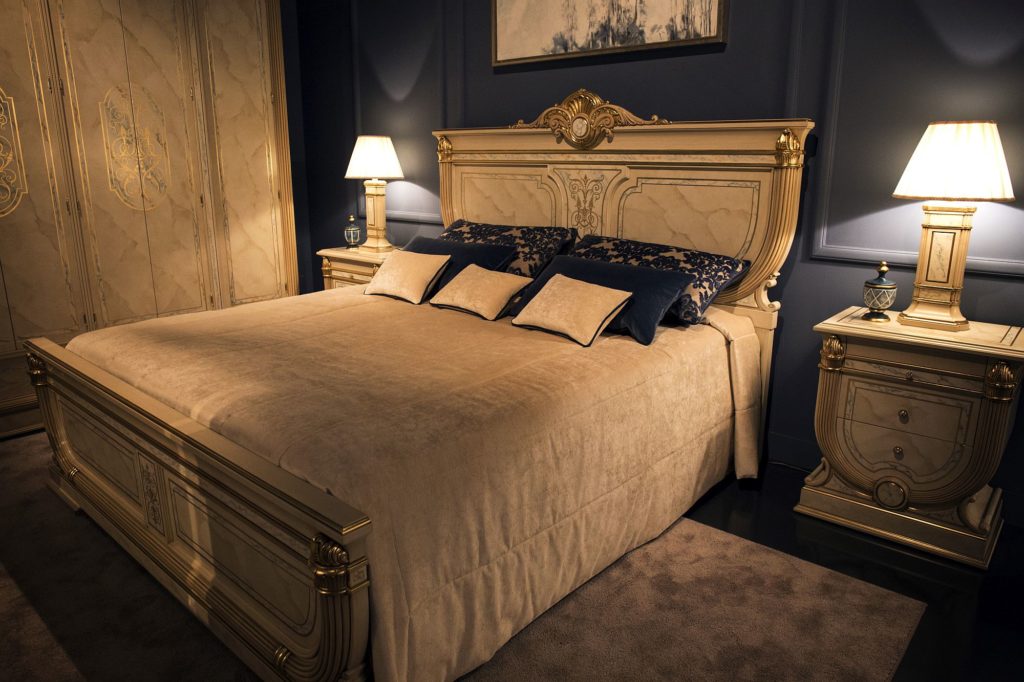 bedside tables with matching table lamps for the lavish traditional bedroom A luxurious bedroom with a regal gold and blue theme.