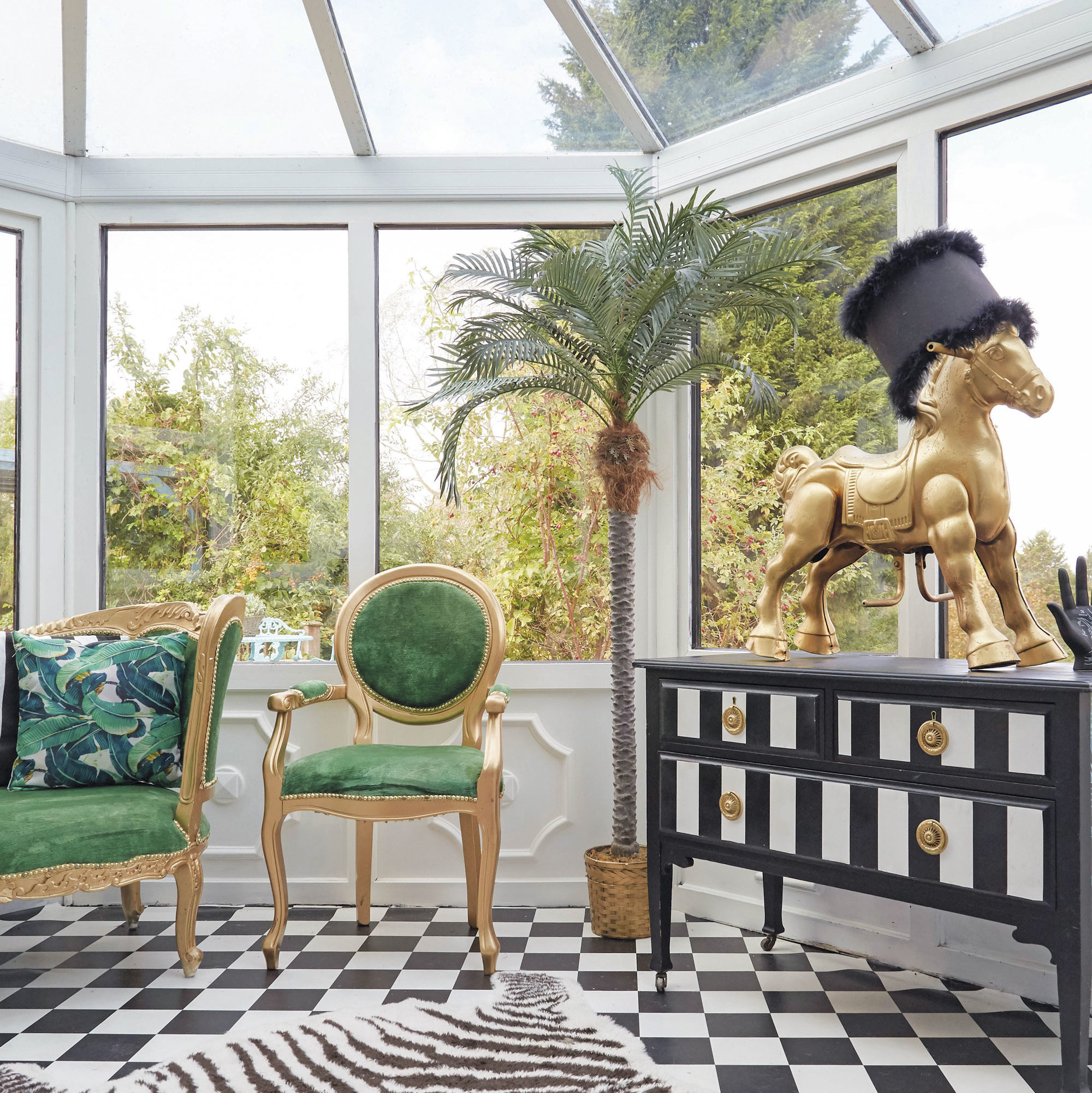 hayley anne brooke b bd edited Whimsical sunroom with green chair and gold horse sculpture.