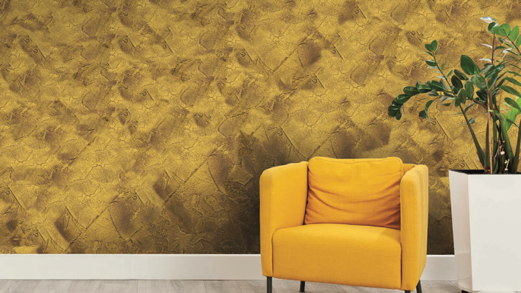 wall texture in earthy tone x Yellow armchair against textured wall with plant.