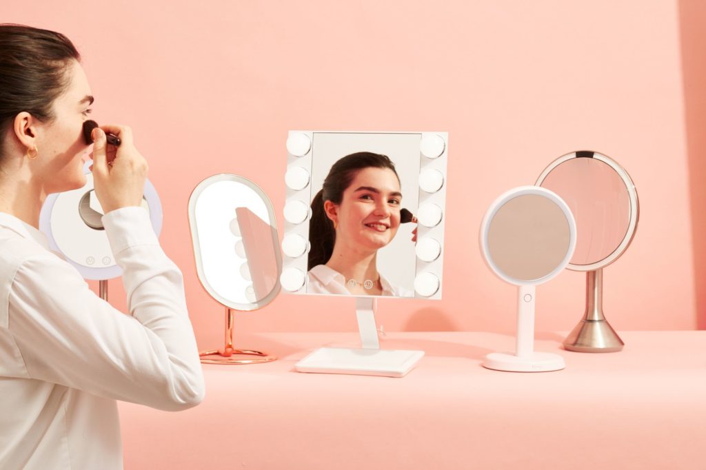 ghk digital index mirror A woman in applying makeup in front of a mirror.