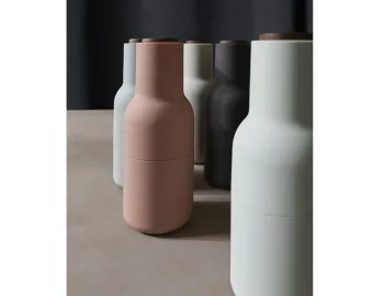 Close grouping of pastel Audo Bottle Grinders with a pink grinder in front and dark wooden lids