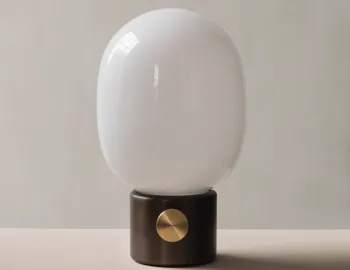 Unlit JWDA Table Lamp with a dark metallic base and gold dial on a pale surface