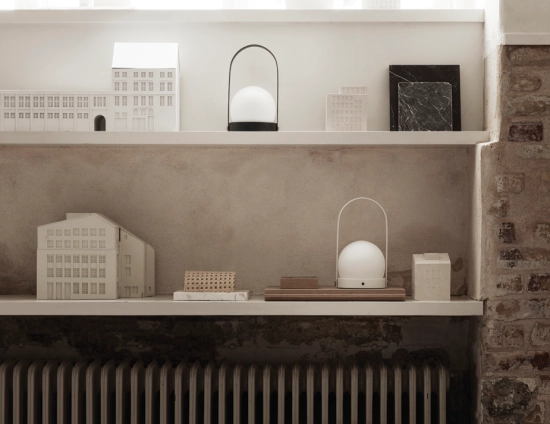 Black and white Carrie Table Lamps displayed on shelves among architectural models and material samples