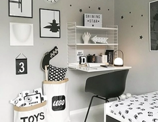 Carrie Table Lamp on a wall-mounted desk beside a bed, toy storage and a black chair in a child’s bedroom