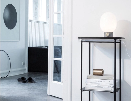 JWDA Concrete Table Lamp on a black trolley beside an open doorway, books and slippers