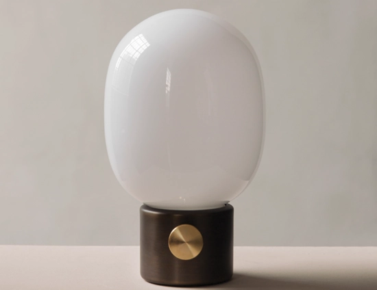 Unlit JWDA Table Lamp with a dark metallic base and gold dial on a pale surface