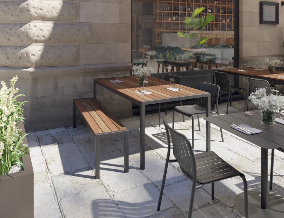 Moonah Dining Table with brown slats and charcoal frame beside a matching bench on a restaurant terrace