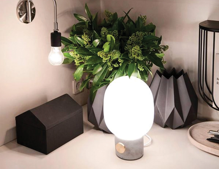 JWDA Concrete Table Lamp among geometric vases, greenery and small boxes on a shelf