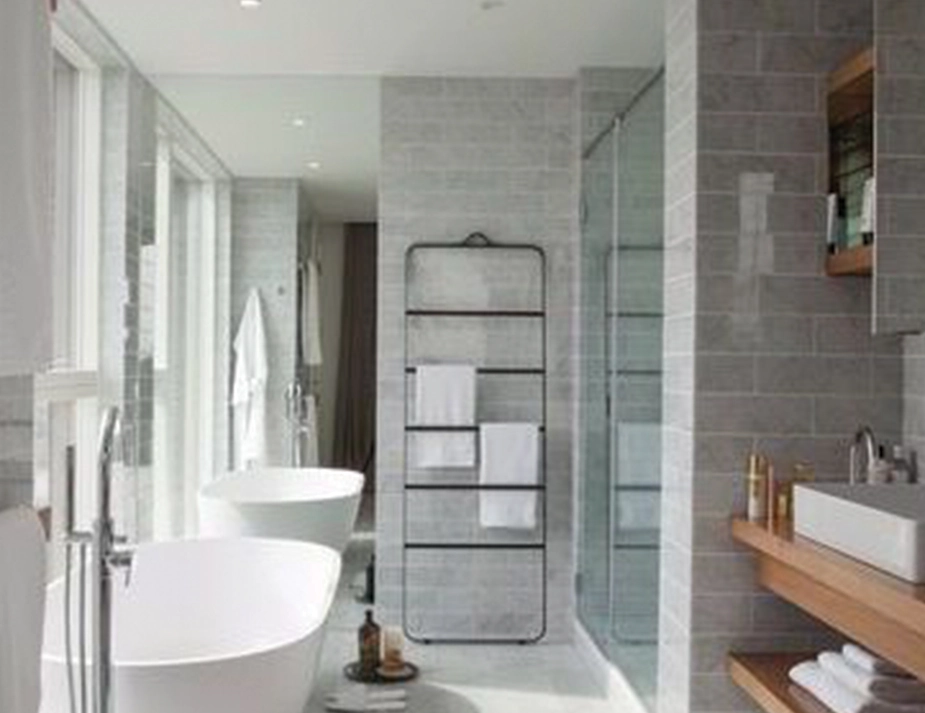 Black Norm Towel Ladder with white towels between a freestanding bath and a glass shower enclosure
